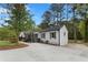 Side view of charming renovated house with a newly paved driveway and manicured landscaping at 2014 Fence Rd, Dacula, GA 30019