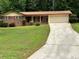 Charming single-story brick home with well-manicured lawn, mature trees, and long driveway at 3190 Cheru Ct, Decatur, GA 30034