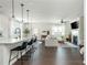 Open-concept living space with a fireplace, hardwood floors, and a kitchen island at 5025 Bryce Ln, Cumming, GA 30040