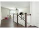 A well-lit loft area featuring a staircase with white railings, dark wood floors, and ample space for versatile use at 5025 Bryce Ln, Cumming, GA 30040