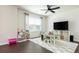Bright playroom with a large window, a ceiling fan, a desk, and shelves providing a comfortable and functional space at 5025 Bryce Ln, Cumming, GA 30040