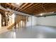 Unfinished basement with exposed beams, painted walls, concrete flooring and stairs to upper level at 6010 Spalding Dr, Atlanta, GA 30350
