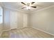 This bedroom offers plush carpet, neutral walls, ample closet space, and a ceiling fan at 6010 Spalding Dr, Atlanta, GA 30350