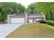 Charming exterior view of a two-story home with a well-kept lawn and convenient two-car garage at 6010 Spalding Dr, Atlanta, GA 30350