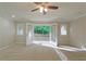 Bright living room with neutral carpet, features a door leading to an outdoor balcony with scenic views at 6010 Spalding Dr, Atlanta, GA 30350