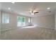 Spacious living room featuring neutral carpet, bright windows, and a ceiling fan for added comfort at 6010 Spalding Dr, Atlanta, GA 30350