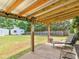 A covered patio with lights overlooks a spacious, grassy backyard with storage sheds at 710 Freeman Dr, Covington, GA 30016