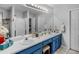 Bathroom featuring double sinks, blue cabinets, a large mirror, and decorative tiling at 710 Freeman Dr, Covington, GA 30016