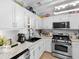 Updated kitchen boasts white cabinets, modern appliances, granite counters, and a subway tile backsplash at 710 Freeman Dr, Covington, GA 30016