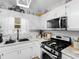 Well-lit kitchen features stainless appliances, granite countertops, and classic white cabinetry at 710 Freeman Dr, Covington, GA 30016