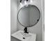 Bathroom features modern lighting, large round mirror, black faucet, and white vanity at 1285 Cedar Brook Dr, Lawrenceville, GA 30043