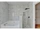 Beautiful bathroom featuring a tub and tiled shower with a black shower head and marble-style tile at 1285 Cedar Brook Dr, Lawrenceville, GA 30043