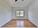 Bright bedroom featuring tray ceilings, hardwood floors, and a large window at 1285 Cedar Brook Dr, Lawrenceville, GA 30043