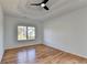 Bedroom with tray ceilings, hardwood floors, fan, and a large window at 1285 Cedar Brook Dr, Lawrenceville, GA 30043