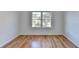Bright bedroom featuring wood floors, white walls, and a large window letting in natural light at 1285 Cedar Brook Dr, Lawrenceville, GA 30043