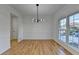 Bright dining room featuring hardwood floors, white walls, modern chandelier, and large windows at 1285 Cedar Brook Dr, Lawrenceville, GA 30043