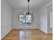 Bright dining room featuring hardwood floors, and a stylish modern chandelier above the window with natural light at 1285 Cedar Brook Dr, Lawrenceville, GA 30043