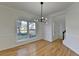 Bright dining room featuring hardwood floors, white walls, modern chandelier, and large windows at 1285 Cedar Brook Dr, Lawrenceville, GA 30043