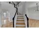 Bright foyer featuring hardwood floors, white walls, and a staircase with black railings and white risers at 1285 Cedar Brook Dr, Lawrenceville, GA 30043