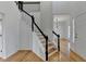 Bright foyer featuring hardwood floors, white walls, and a staircase with black railings and white risers at 1285 Cedar Brook Dr, Lawrenceville, GA 30043