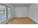 Sunlit living area with hardwood floors and a view of the landscaped front yard through updated windows at 1285 Cedar Brook Dr, Lawrenceville, GA 30043