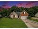 Charming brick home with a manicured front lawn and a two-car garage nestled among lush trees at 1290 Silverstone Trl, Jonesboro, GA 30238
