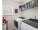 Functional laundry room equipped with modern washer and dryer, shelf, and ample counter space at 1290 Silverstone Trl, Jonesboro, GA 30238