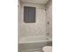 This bathroom features a shower over tub with a gray tile wall and new shower head at 4090 Mark Todd Ct, Hoschton, GA 30548