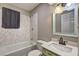 The bathroom has a shower over tub, decorative vanity and white marble style tiles at 4090 Mark Todd Ct, Hoschton, GA 30548