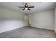 The bedroom features neutral walls, plush carpet, and a ceiling fan at 4090 Mark Todd Ct, Hoschton, GA 30548