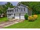 Split-level home featuring a two-car garage and front yard with shrubs and lawn at 4090 Mark Todd Ct, Hoschton, GA 30548
