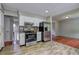 Open kitchen with stainless steel appliances, white cabinets, and wood-look tile flooring at 4090 Mark Todd Ct, Hoschton, GA 30548