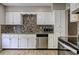 Well-equipped kitchen featuring white cabinets, stainless steel appliances and modern tile backsplash at 4090 Mark Todd Ct, Hoschton, GA 30548
