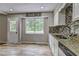 Bright kitchen with granite countertops, a stainless steel dishwasher, and a window view at 4090 Mark Todd Ct, Hoschton, GA 30548