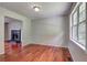 Cozy living room with hardwood floors, a fireplace, and natural light from the window at 4090 Mark Todd Ct, Hoschton, GA 30548