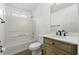 Well-lit bathroom featuring a shower-tub combo, white tiling, and modern vanity at 7434 Chads Cir, Jonesboro, GA 30236