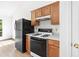 Kitchen area featuring a gas stove, white counters, black appliances, and wooden cabinets at 7434 Chads Cir, Jonesboro, GA 30236