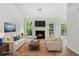 Staged living room with fireplace, two sofas, area rug, and many windows at 7434 Chads Cir, Jonesboro, GA 30236