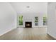 Bright living room featuring a cozy fireplace, large windows, and hardwood flooring at 7434 Chads Cir, Jonesboro, GA 30236
