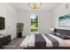 Staged main bedroom features a dark gray bed set, art, dark wood furniture, and nice lighting at 7434 Chads Cir, Jonesboro, GA 30236