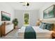 Staged main bedroom showcases a neutral palette, large window, and decorative plants at 7434 Chads Cir, Jonesboro, GA 30236