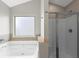 Modern bathroom with a luxurious soaking tub and a glass-enclosed shower at 9120 Alden Dr, Locust Grove, GA 30248