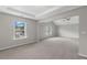 Spacious bedroom with neutral carpet, tray ceiling, and natural light from large window at 9120 Alden Dr, Locust Grove, GA 30248