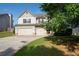 Charming two-story home with a two-car garage and a lush green lawn at 9120 Alden Dr, Locust Grove, GA 30248