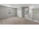Carpeted loft with white railing, natural light, and view into hallway at 9120 Alden Dr, Locust Grove, GA 30248