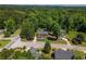 Aerial view of two-story brick home with lush lawn in maturely wooded neighborhood at 100 Chadwick Pl, Villa Rica, GA 30180