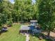 Aerial view of backyard with a covered patio, shed, green lawn, walkway, and mature trees at 100 Chadwick Pl, Villa Rica, GA 30180