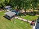 Aerial view of the backyard featuring lush lawn, covered patio, storage building, and mature trees at 100 Chadwick Pl, Villa Rica, GA 30180
