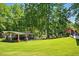 Expansive backyard with a covered patio, lush lawn, and mature trees providing shade and privacy at 100 Chadwick Pl, Villa Rica, GA 30180