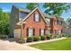 Side view of a red brick home with a two-car garage and mature landscaping at 100 Chadwick Pl, Villa Rica, GA 30180